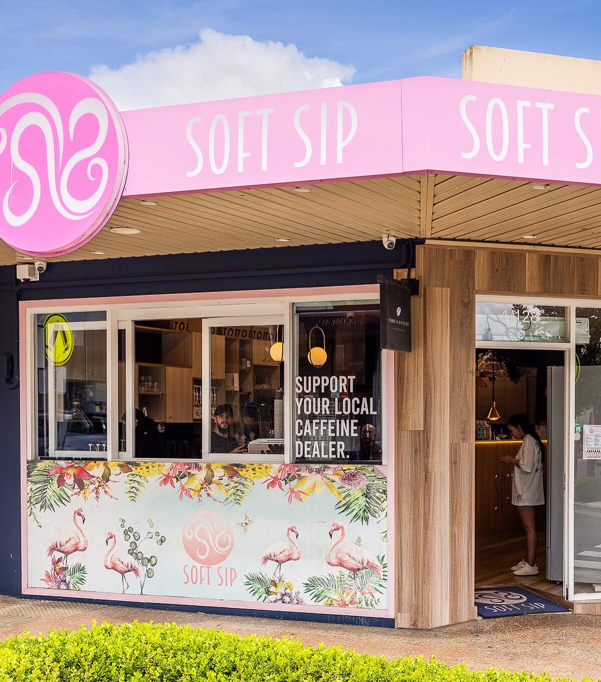 Soft Sip's pink shopfront on Waterloo Road, Greenacre, with the round swirl sign and flamingo window art